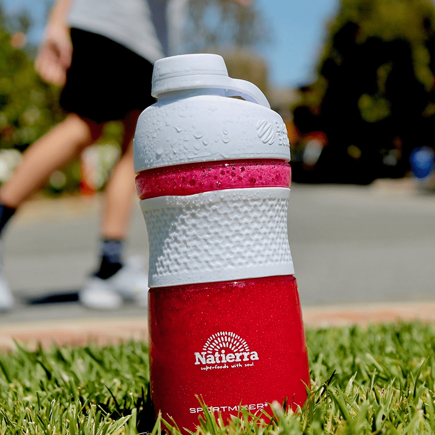 Shaker with pink Blast smoothie, with basketball player in background