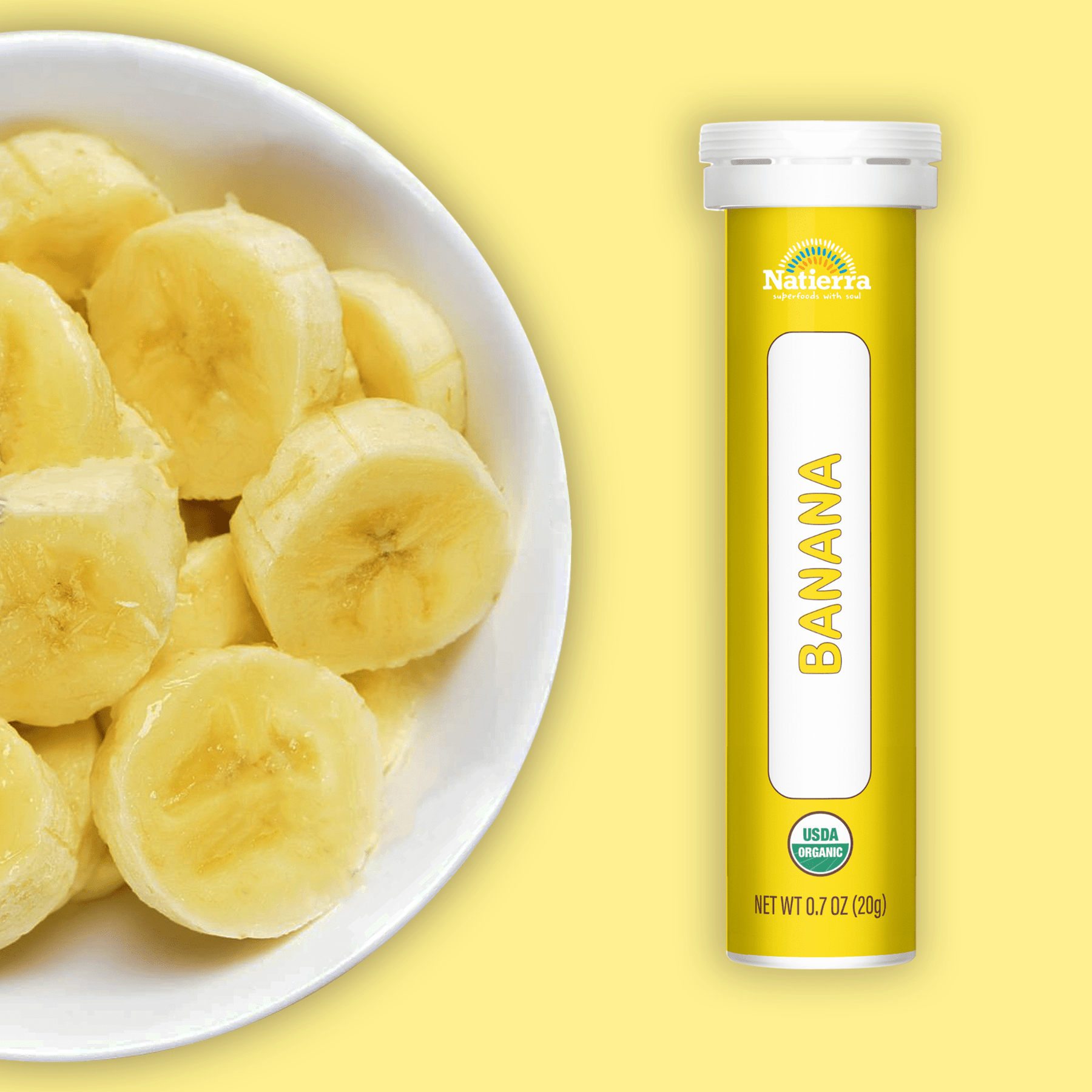 Natierra Organic Banana Smoothie Powder tube next to bowl of bananas