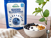 Bag of Premium Freeze-Dried Blueberries in front of a bowl of yogurt with cereals and freeze-dried bluberries